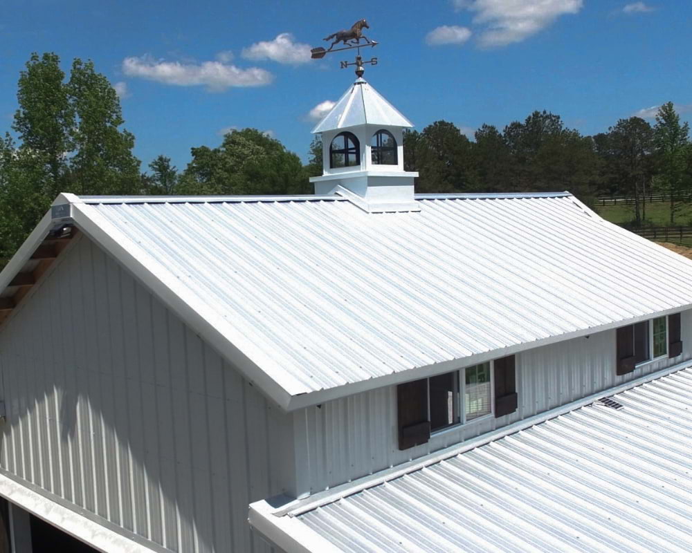 Blue Steel Manufacturing galvanized metal roof on barn with cupola